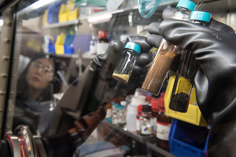 Gloved hands hold vials of silicon materials.